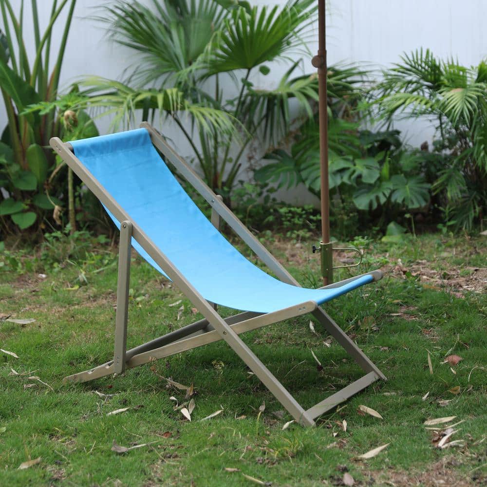 A blue folding wood outdoor lounge chair placed on grass.