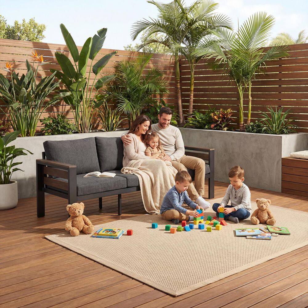 Family relaxing on a graphite gray 3-seat outdoor metal sofa.