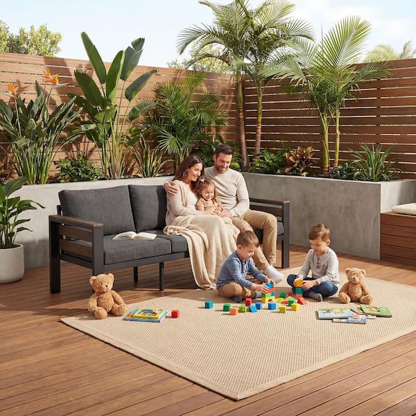 Family relaxing on a graphite gray 3-seat outdoor metal sofa.