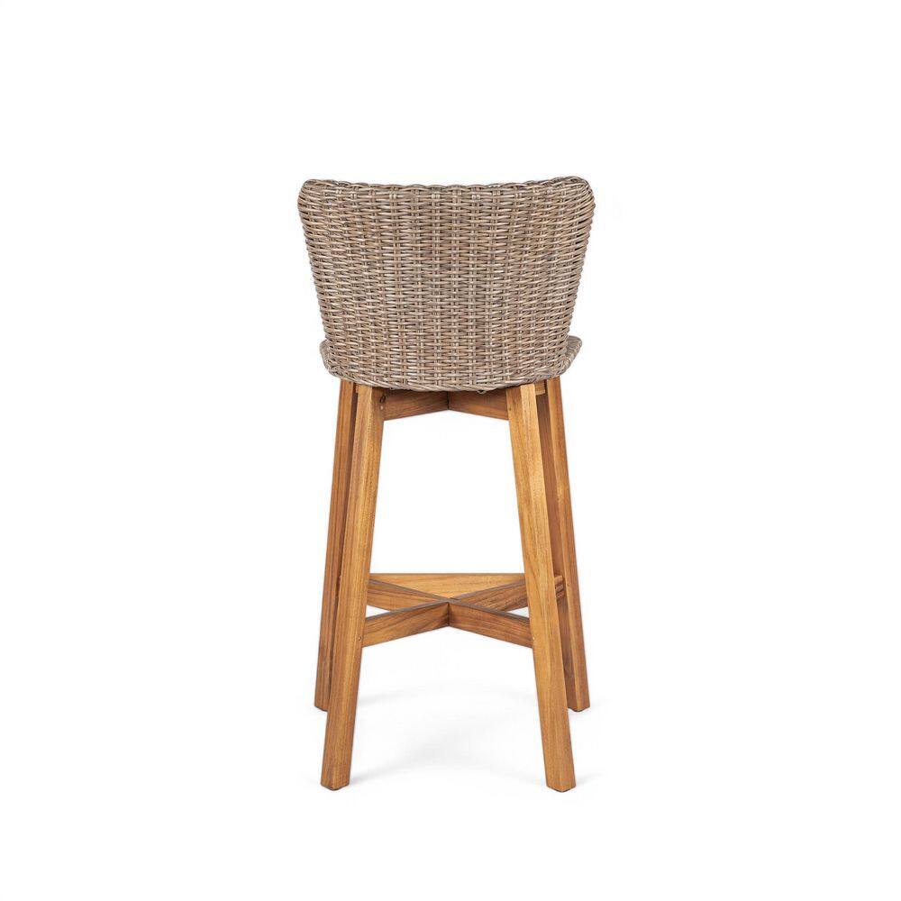 Back view of a woven wicker bar stool with teak finish wooden legs.