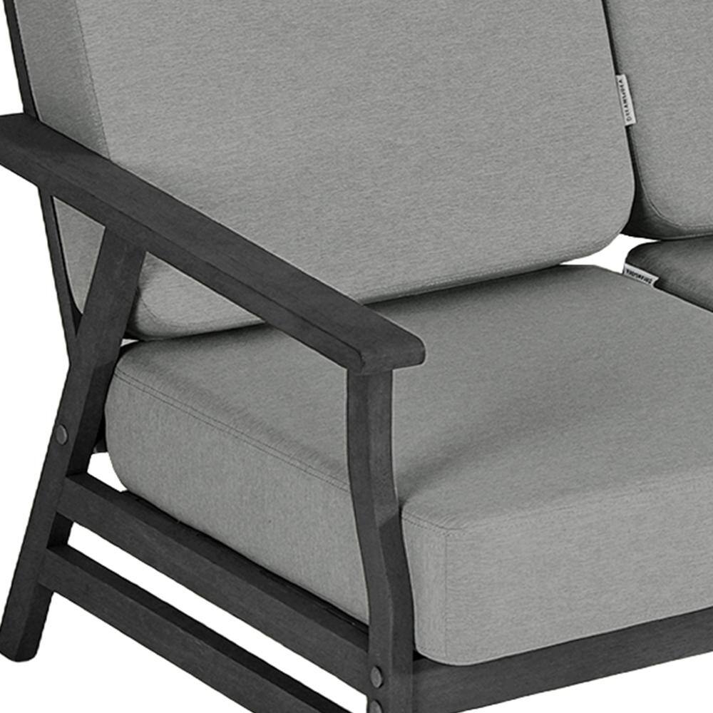 Close-up detail of the wooden frame and cushion of an outdoor sofa.