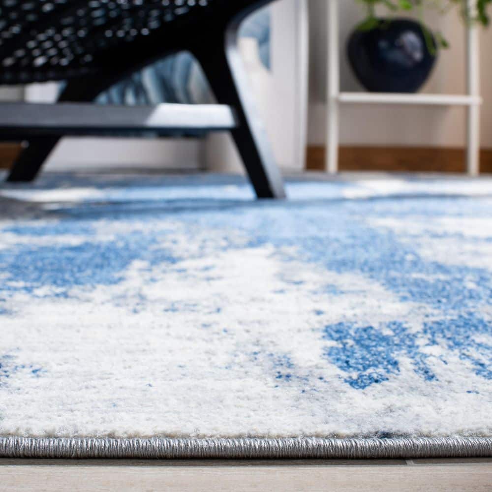 Blue and Ivory Abstract Synthetic Area Rug, 5'3" x 7'6"
