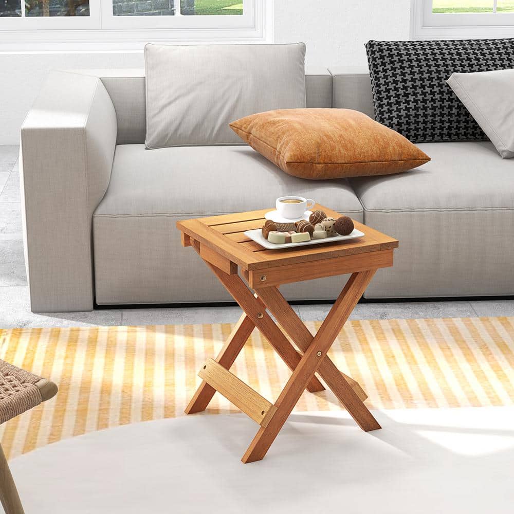 Wooden side table in a bright living room setting with a sofa.
