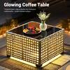 Close-up of the glowing gray wicker coffee table with a black glass top.