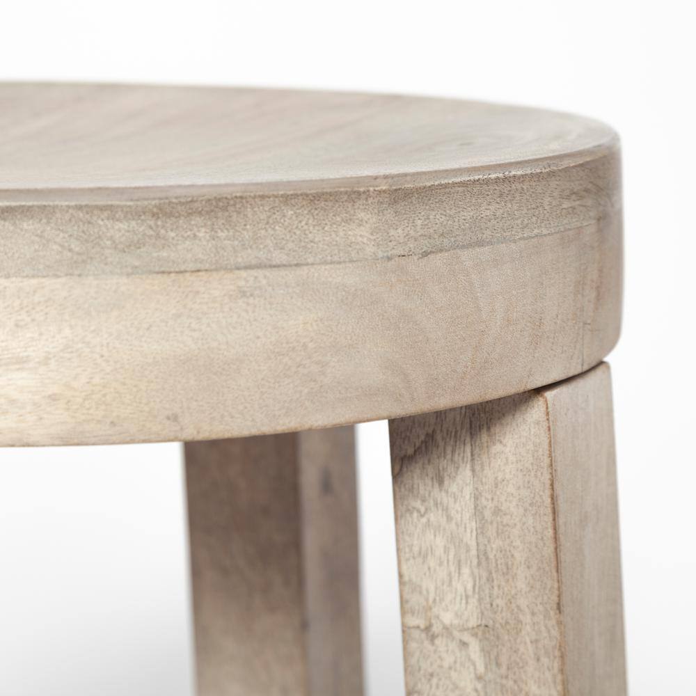 Close-up detail of the top and leg of a wooden stool.