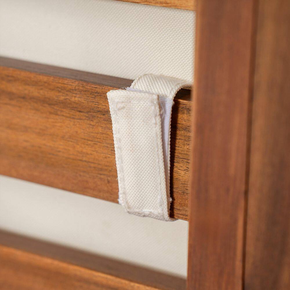 Close-up of the white fabric strap securing the beige seat cushion to the wooden stool frame.