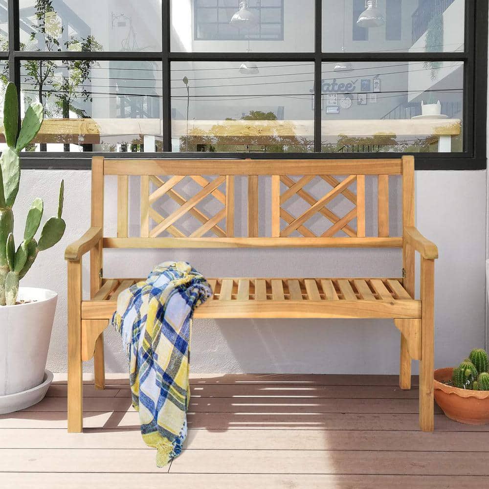 Wooden bench on a deck with a plaid blanket.