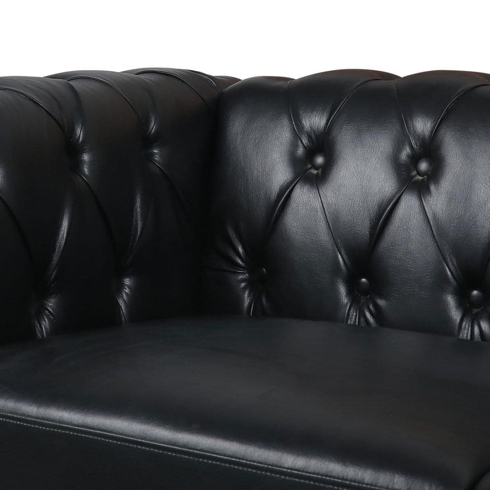 Close-up of button tufting on a black faux leather sofa