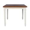 End view of the dining table showing the wood top and white turned legs.