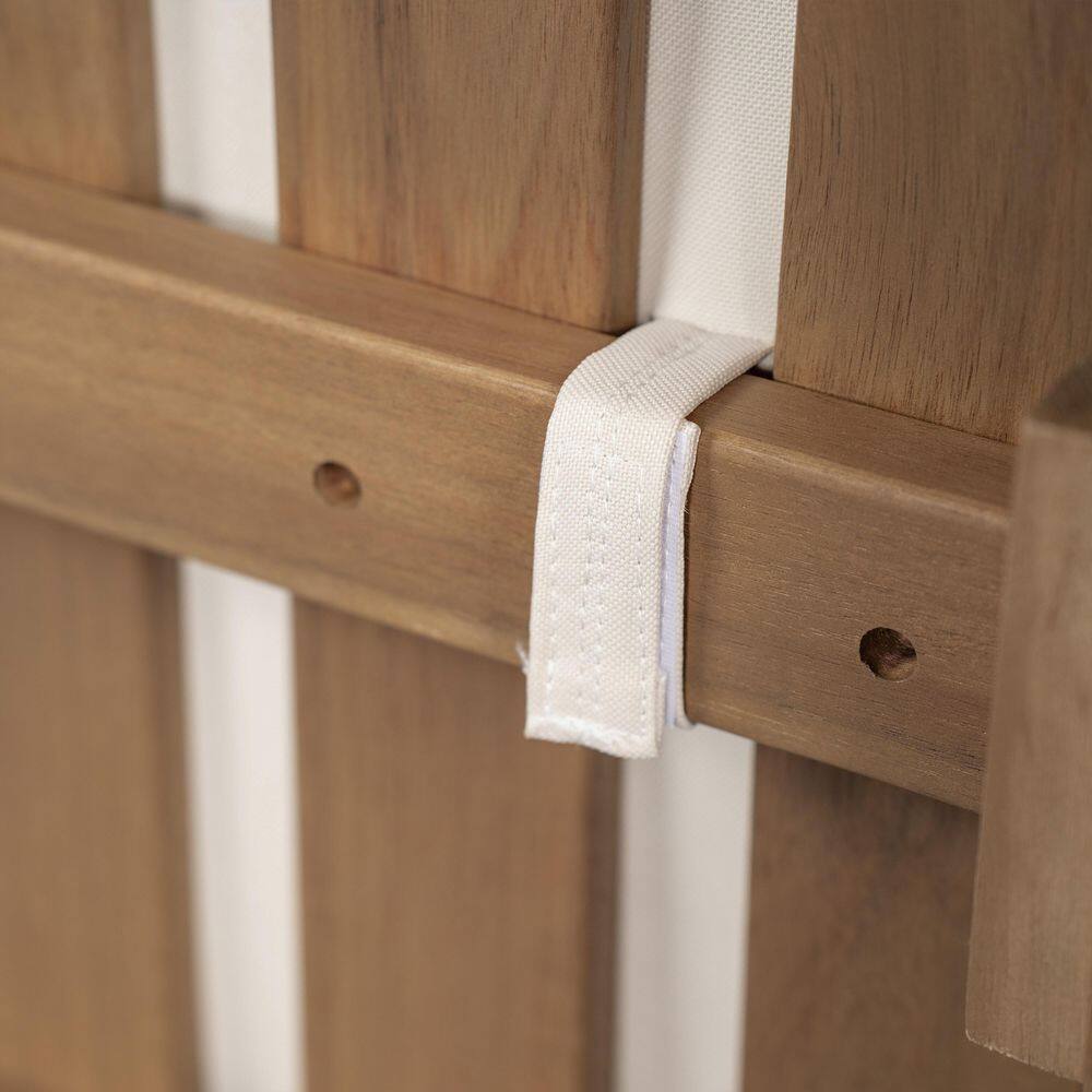 Close-up detail of the wooden frame and strap on an outdoor chair.