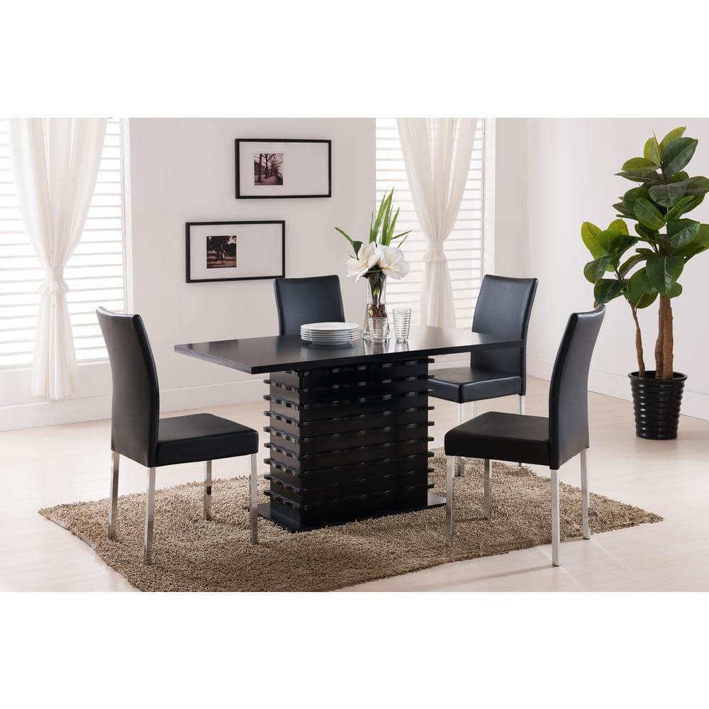 Black dining table set with four chairs in a living room.