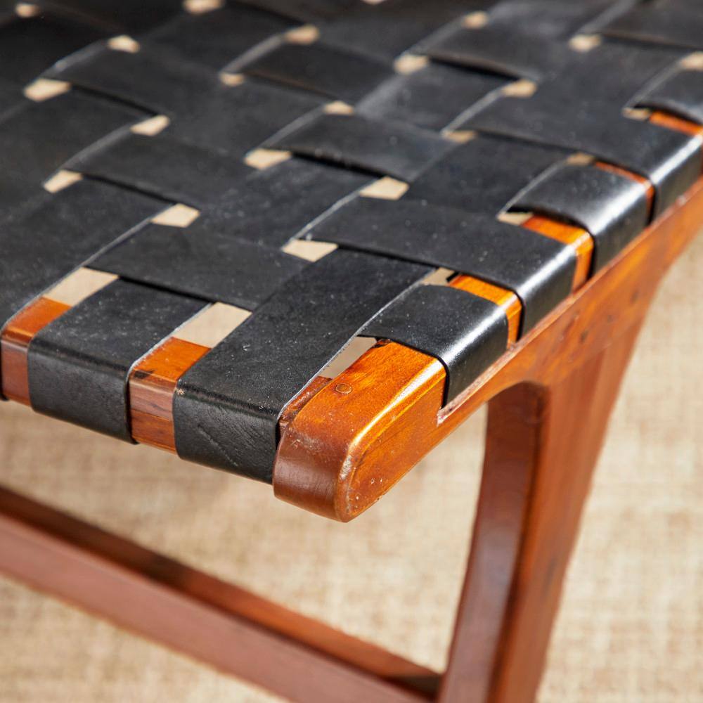 Close-up of the black woven leather and brown wood frame of the accent chair.