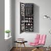 Tall brown wall-mounted jewelry armoire in a living room setting.