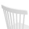 Close-up of the vertical slats forming the backrest of a white wooden dining chair.