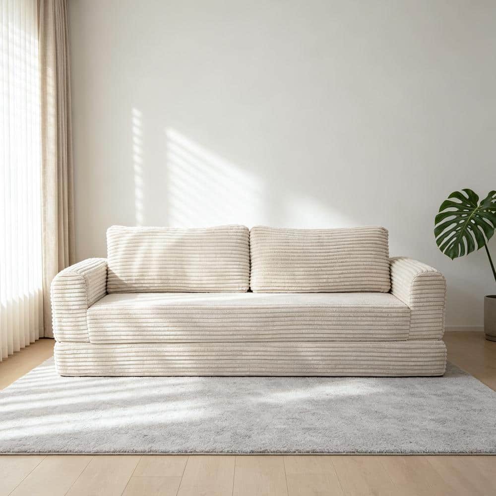 Beige white corduroy sofa bed in a bright living room.