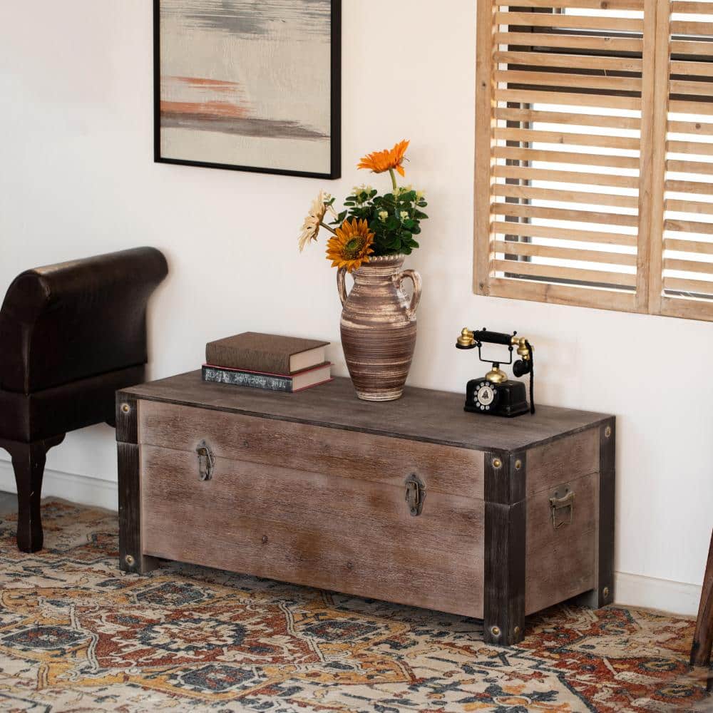 Rustic wooden storage trunk bench in an entryway setting.