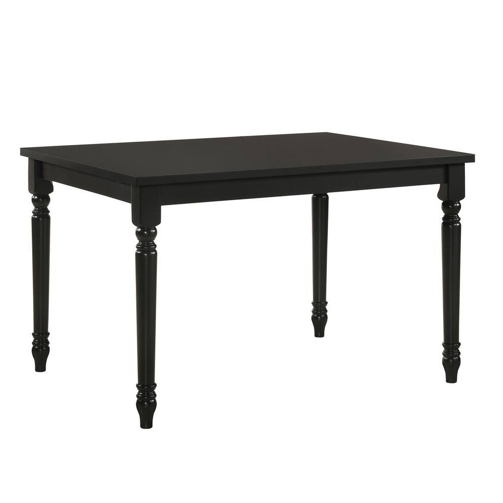 Three-quarter view of a black wood farmhouse dining table.