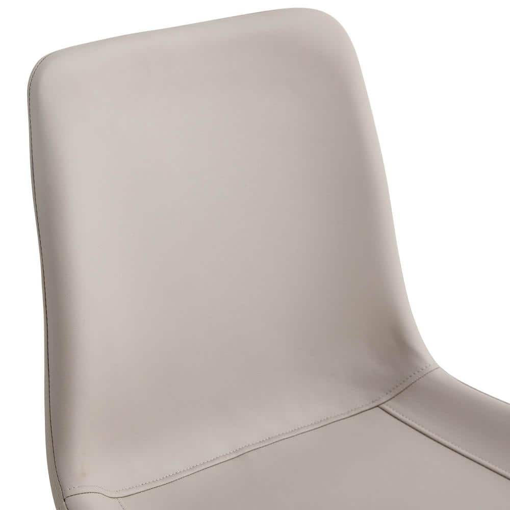 Close-up of the light gray faux leather backrest of a dining chair.