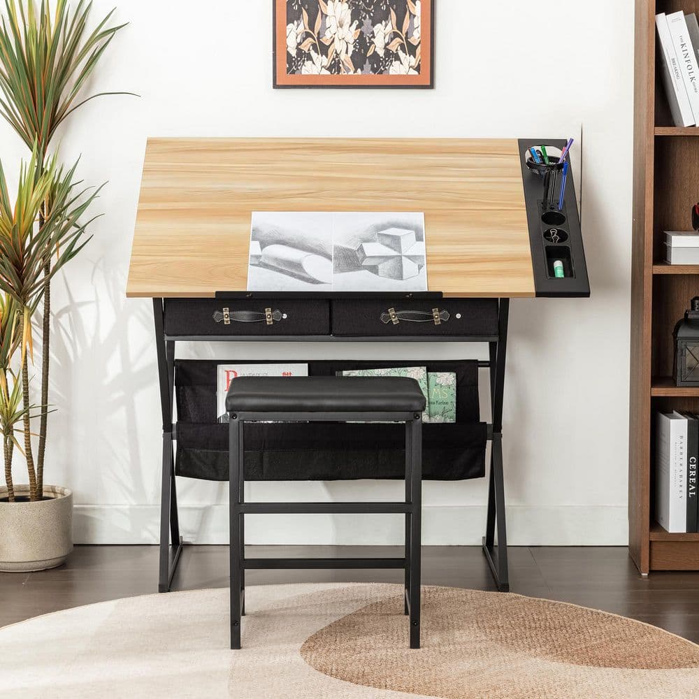 Drafting table with oak top and black frame, shown in a room setting with a stool.