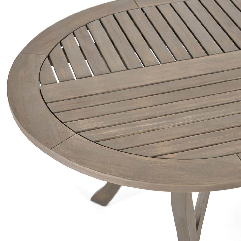 Close-up of the curved edge and slatted top of the gray acacia wood table.