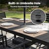 Close-up of the built-in umbrella hole on a black slatted dining table.