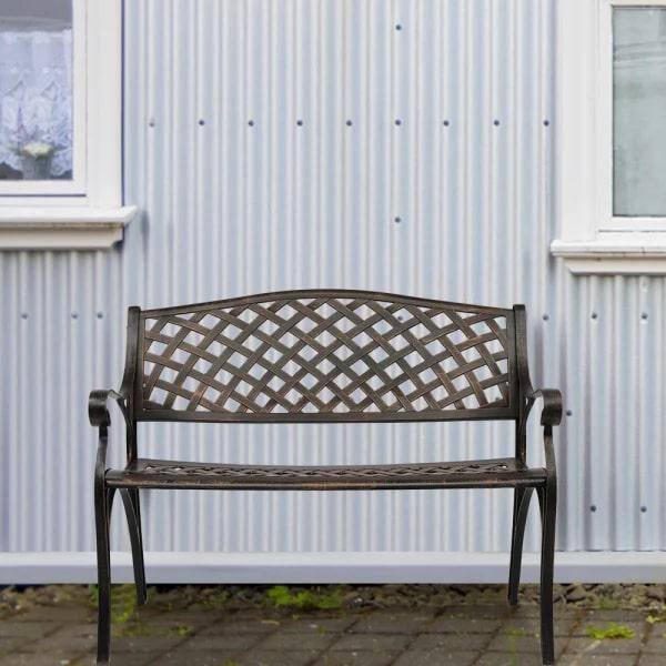 Bronze cast aluminum outdoor bench against a corrugated wall