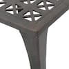 Close-up of geometric cutouts on the side panel of the metal table.