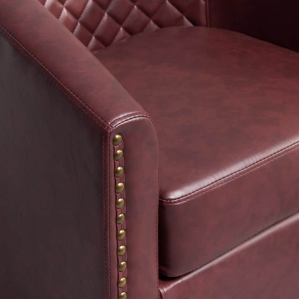 Close-up of red faux leather chair with gold nailhead trim.