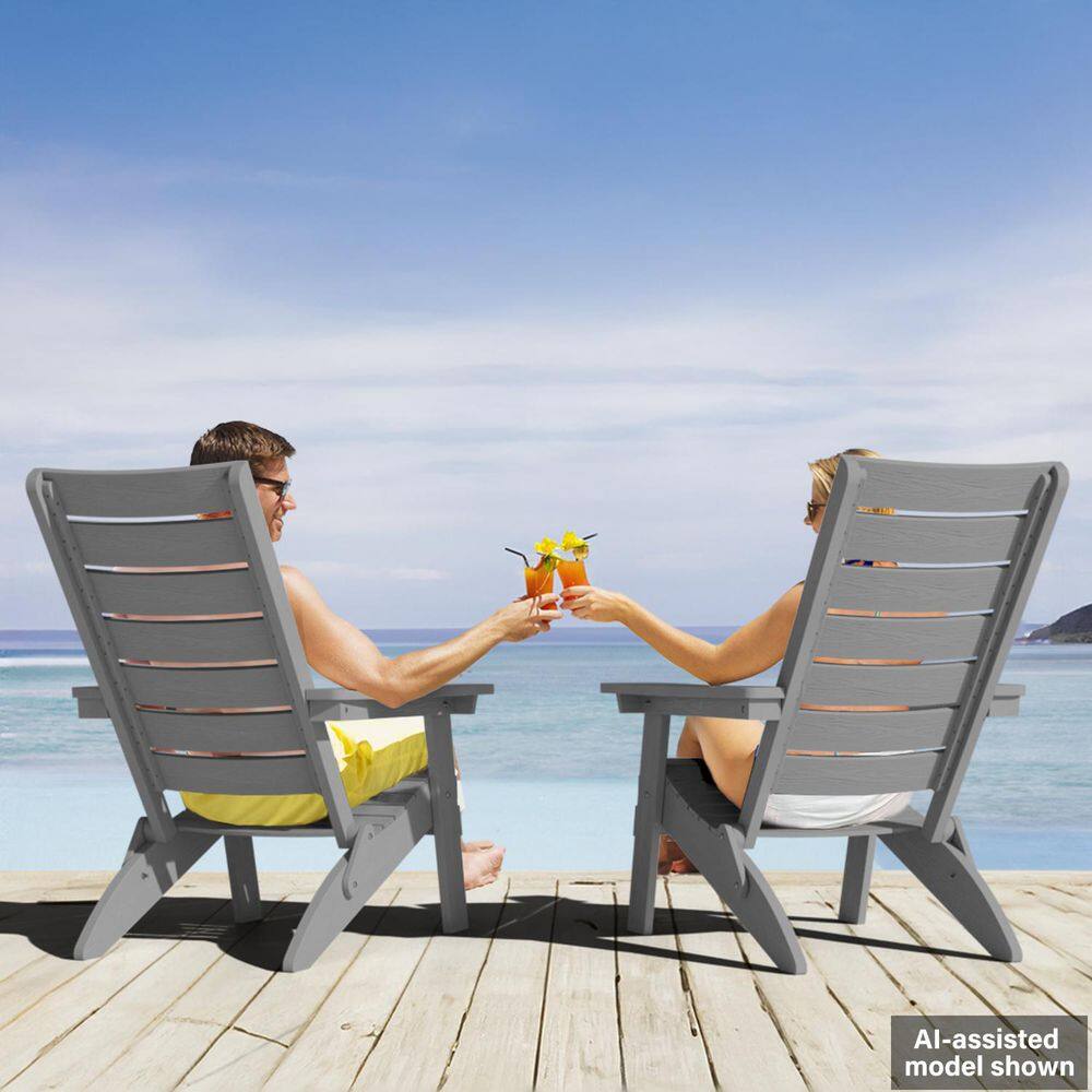 A man and a woman sitting in grey Adirondack chairs, clinking drinks.
