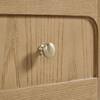Close-up of a brushed metal handle on a wood cabinet.