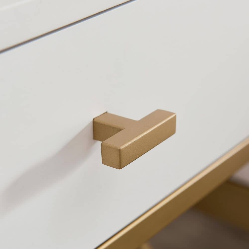 Close-up of the satin gold T-bar handle on the white drawer.