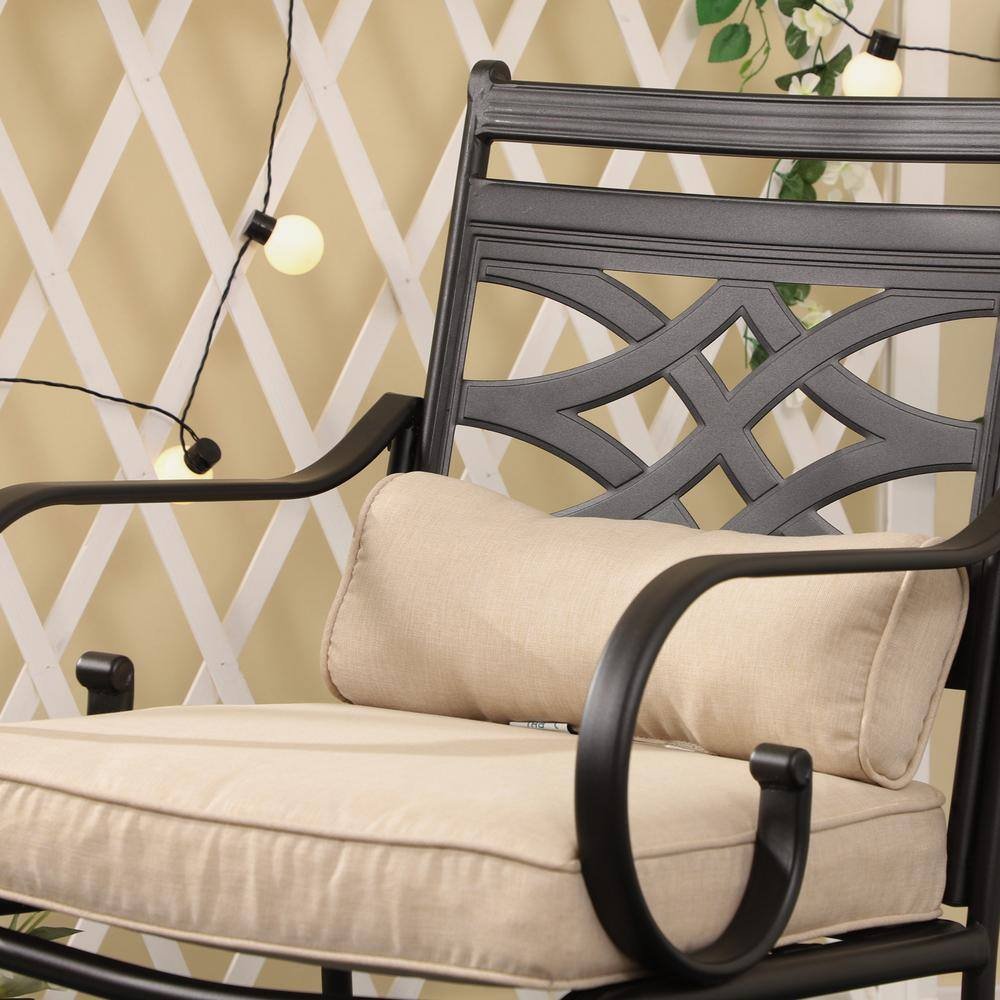 Black metal dining chair with beige cushions in an outdoor setting.