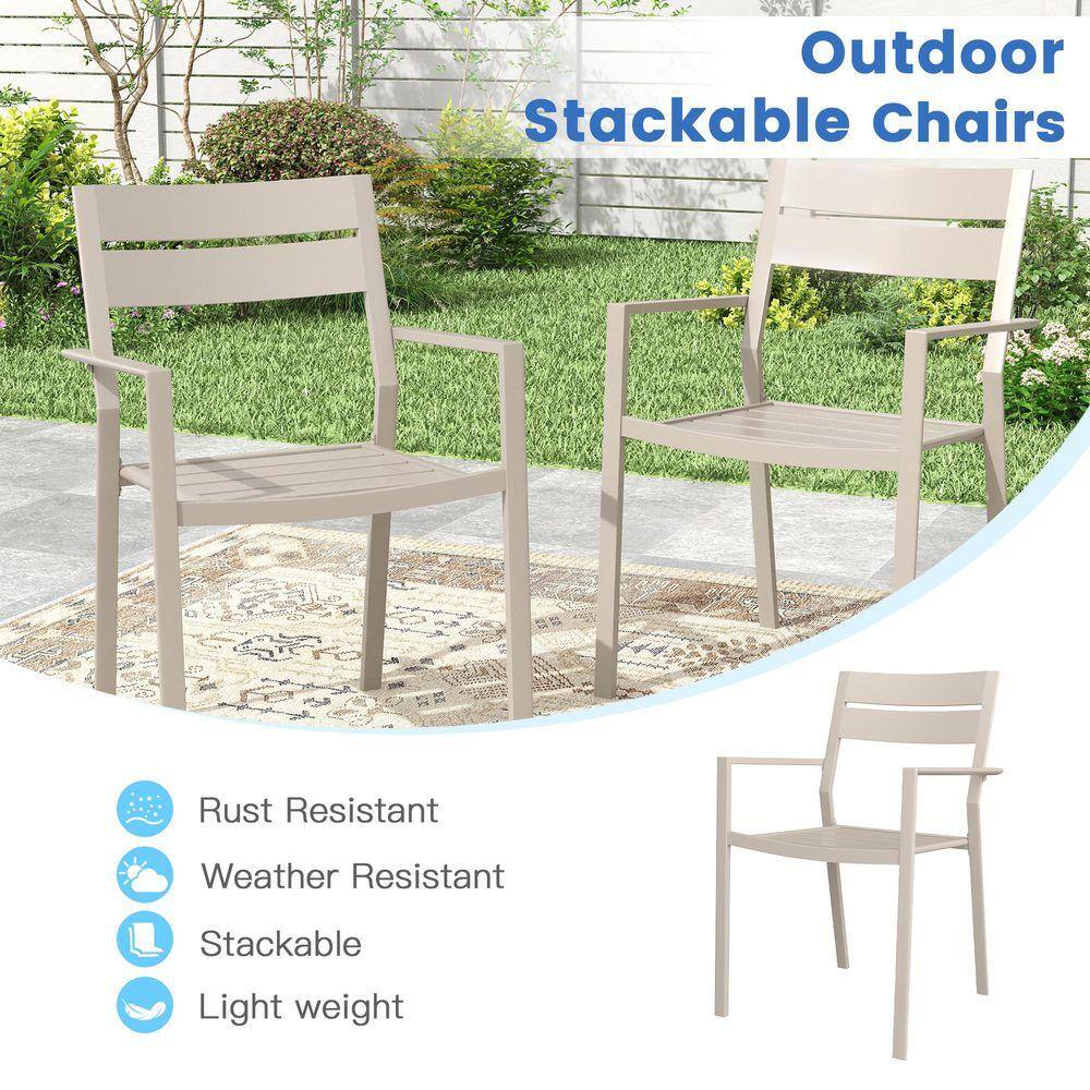 Two sandshell colored metal outdoor chairs shown in a lifestyle setting.