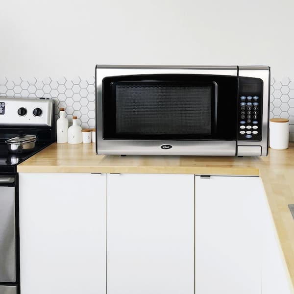 https://images.thdstatic.com/productImages/2c3fbf0e-30d5-4c9c-a5ff-8734d1c1e914/svn/black-stainless-steel-oster-countertop-microwaves-985116503m-76_600.jpg