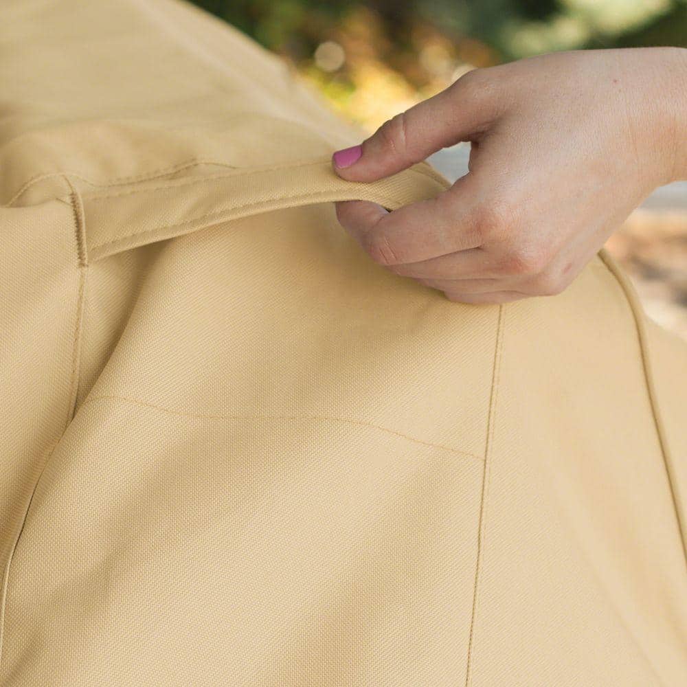 A close-up of a hand touching the beige fabric of the cover.