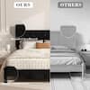 Close-up of a black tufted headboard and upholstered bed frame.