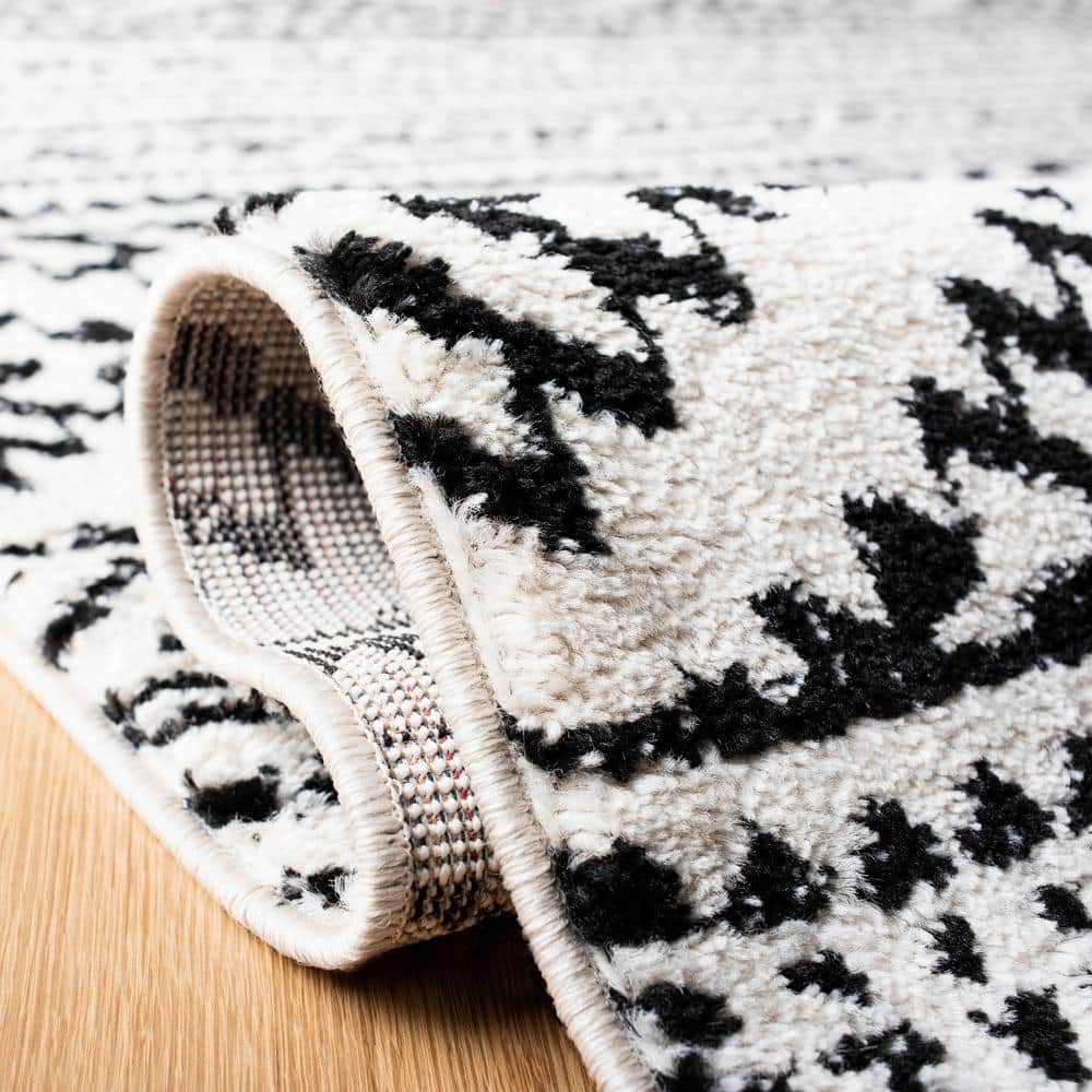 Ivory and Black Geometric Synthetic 9' x 12' Area Rug