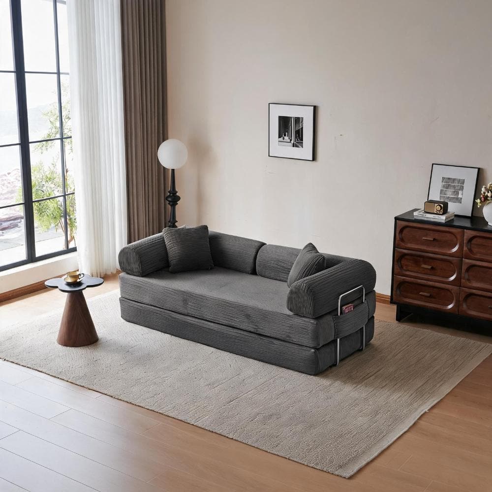 Gray corduroy floor sofa bed next to a window with plants.