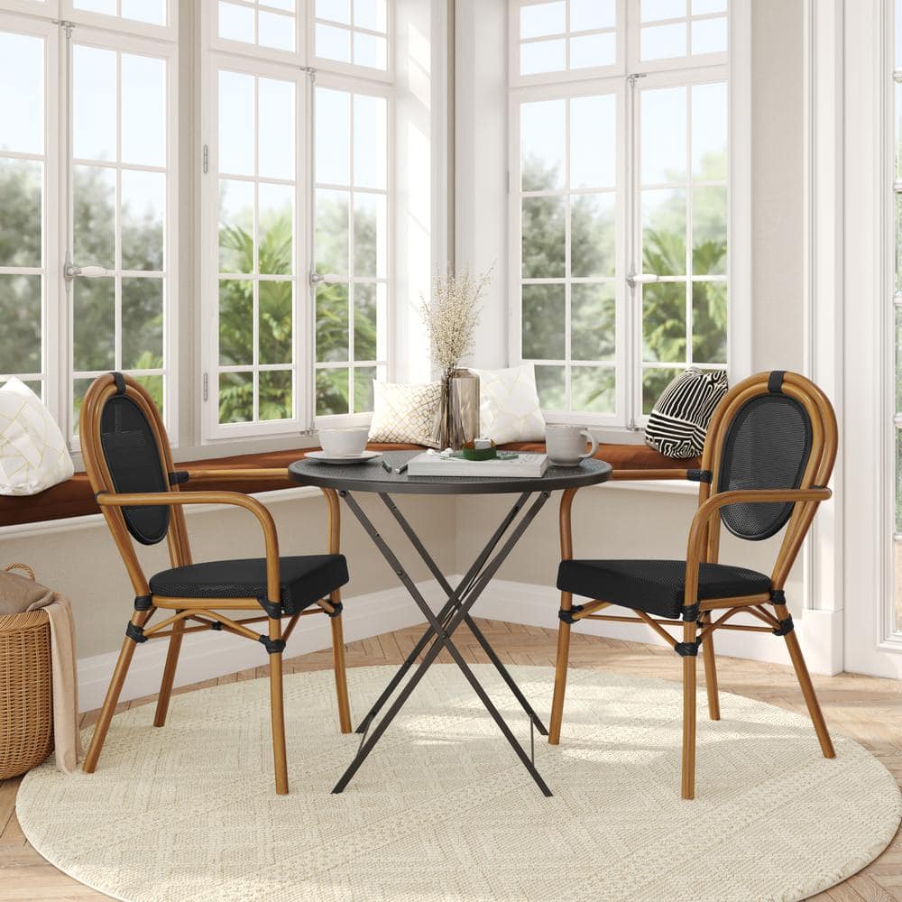 Two brown aluminum outdoor dining chairs with black mesh around a black table.