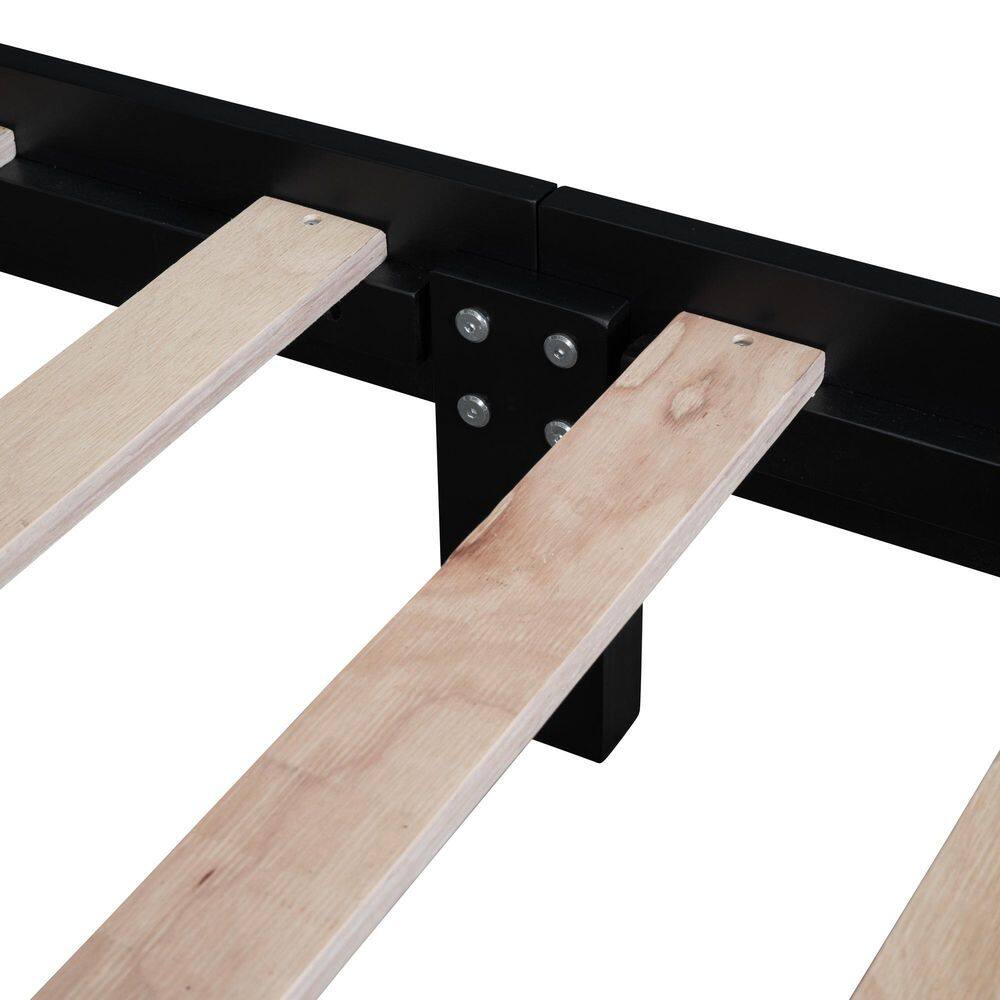 Close-up of the natural wood slats and black support frame of the platform bed.