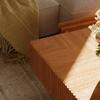 Close-up detail of the wood grain and fluted side of the table.