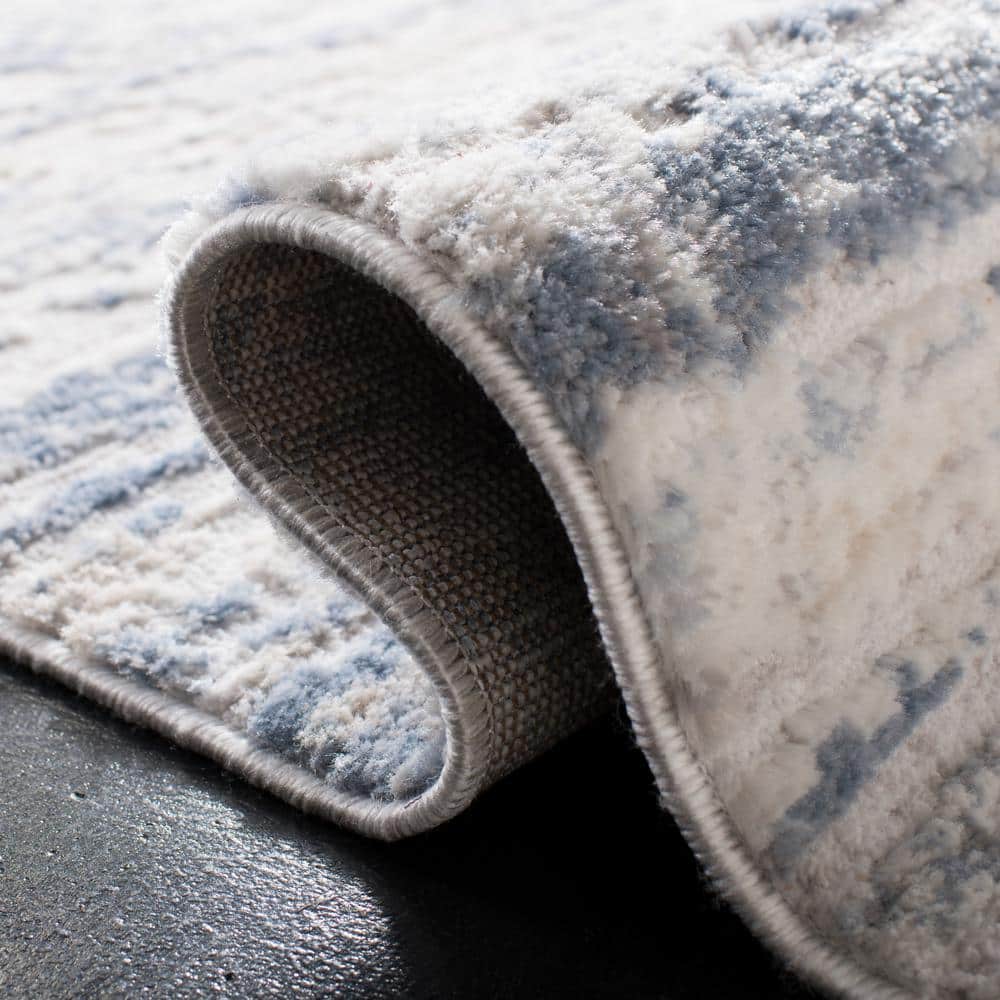 Ivory and Blue Abstract 6' x 9' Stain-Resistant Synthetic Rug