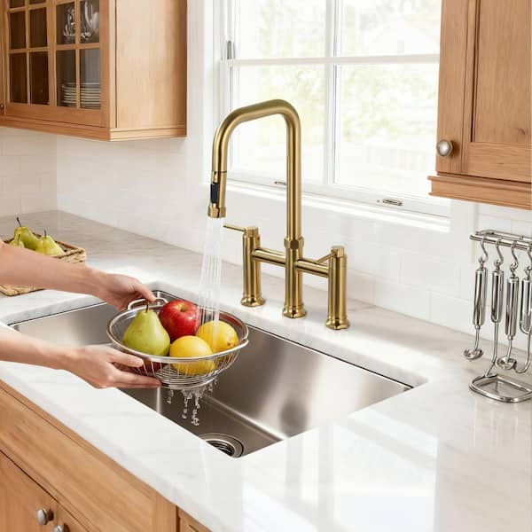 Brass Double Handle Deck Mounted Bridge Kitchen Faucet with Pull-Down Spray Head in Brushed Gold