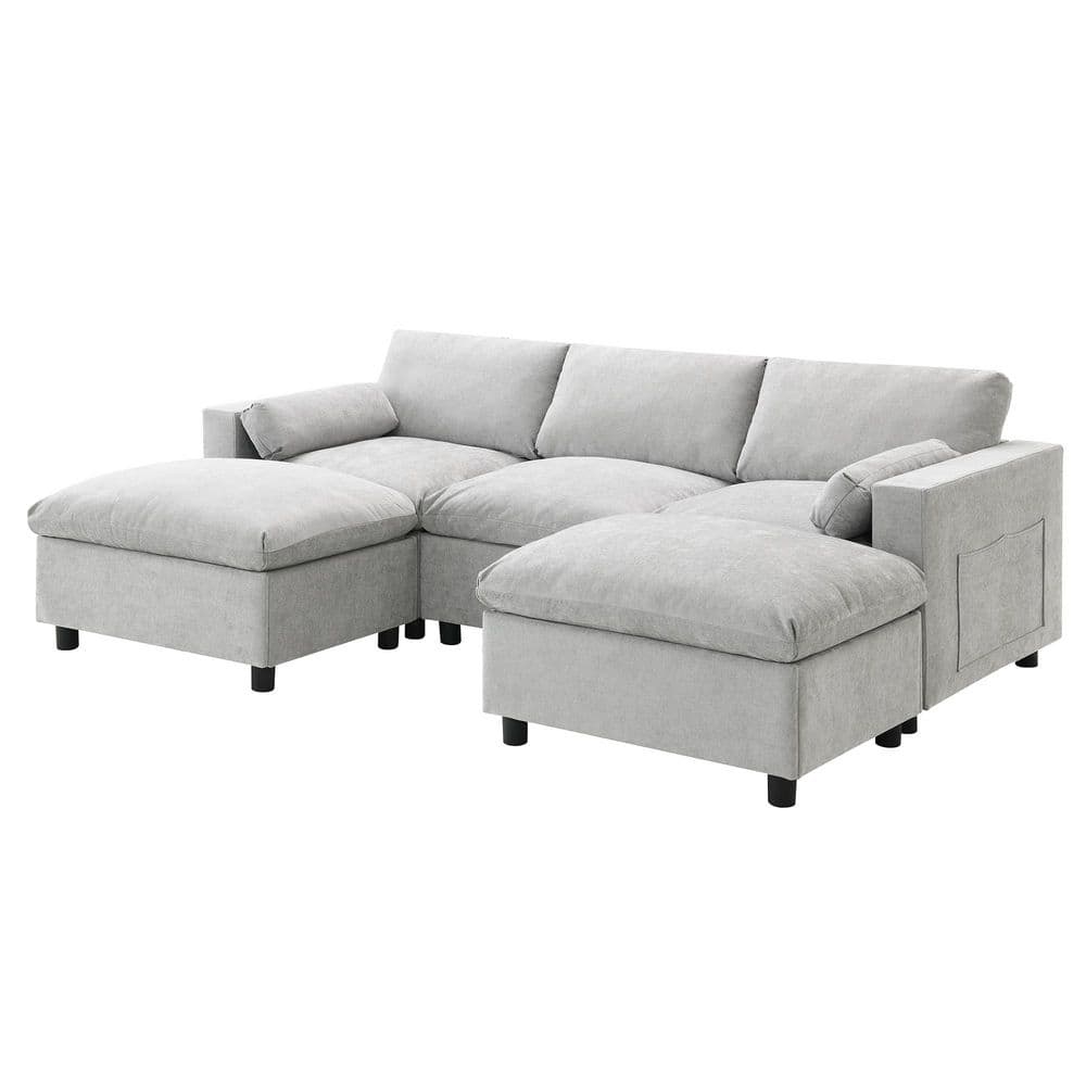 Gray sectional sofa with two ottomans in a styled arrangement.