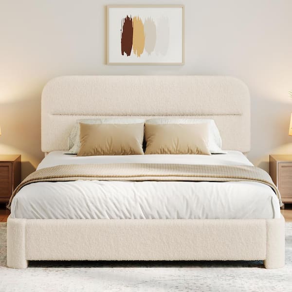 Cream upholstered platform bed with beige pillows and white bedding.