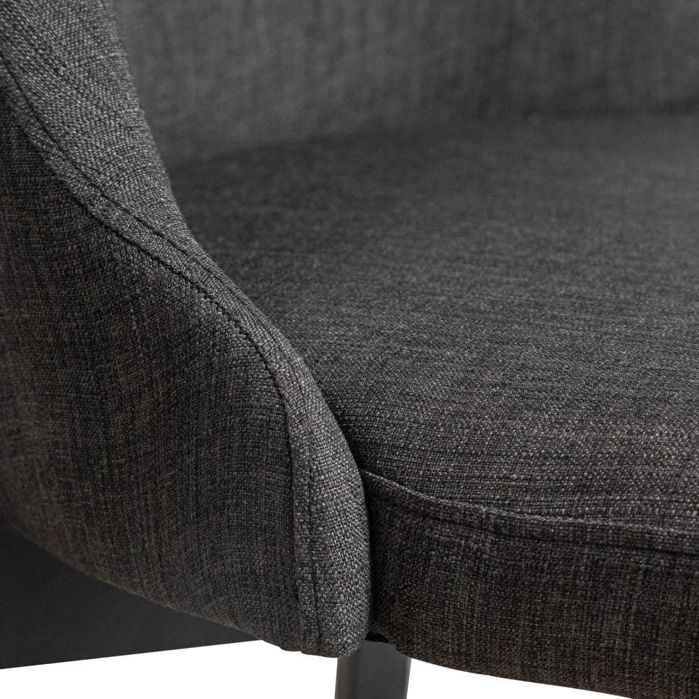 Close-up detail of the dark gray upholstery and stitching on a dining chair.