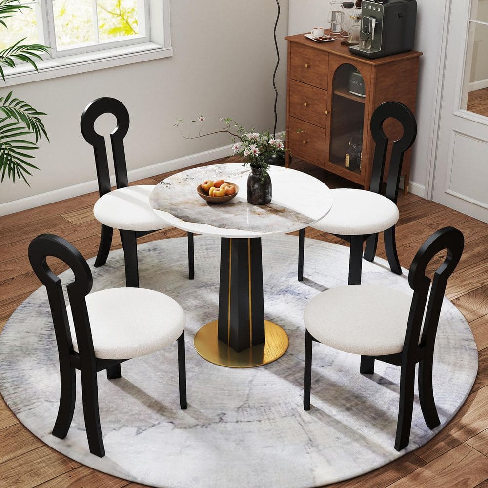 A dining set including a round marble top table and three black and white chairs.