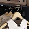 Close-up of hanging rod and clothes inside wardrobe.