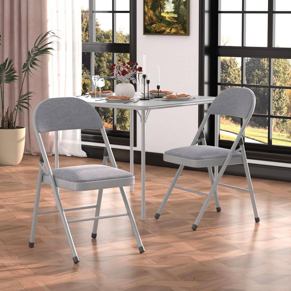 Two gray folding chairs placed at a white table in a dining room.