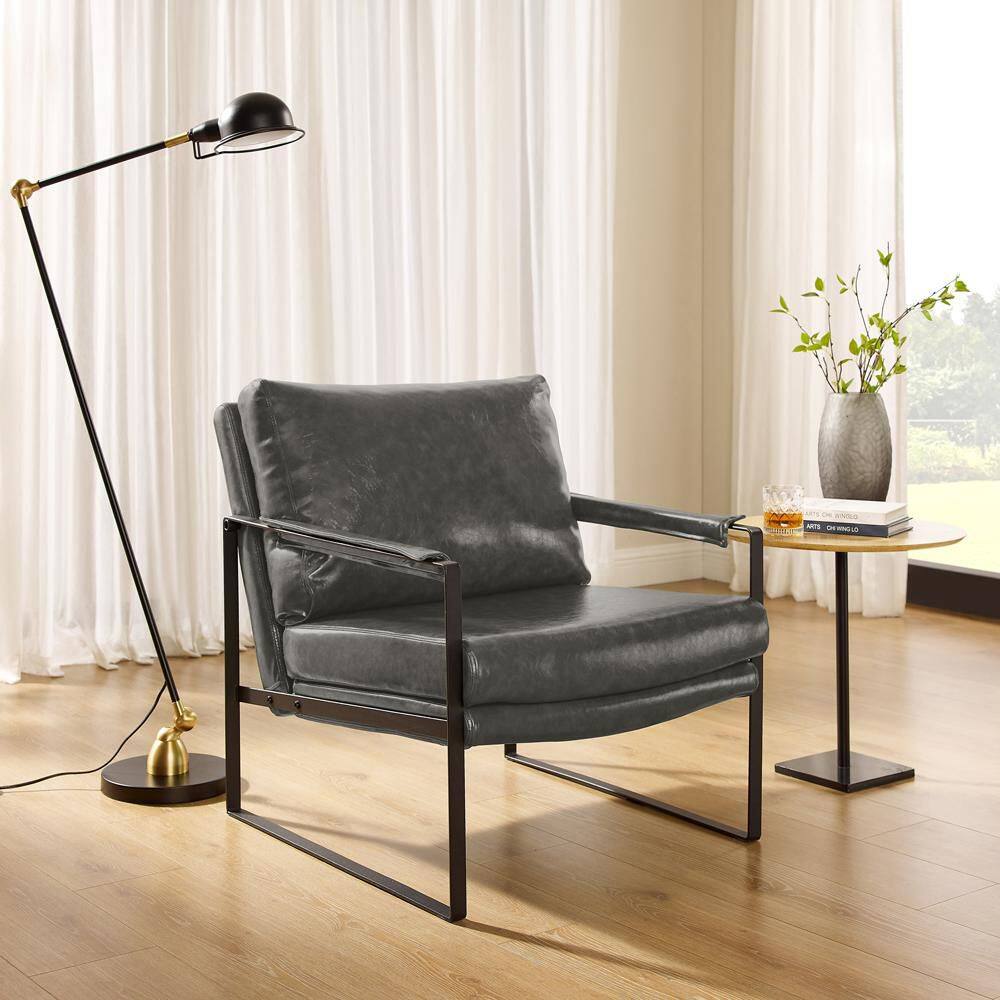 Gray faux leather accent chair with a black steel frame next to a side table.